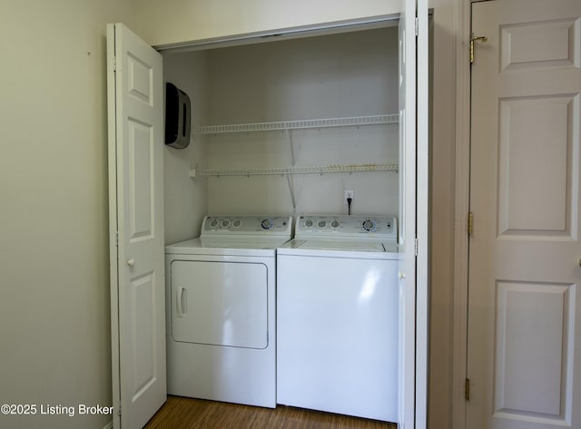 laundry area with laundry area, wood finished floors, and washer and dryer