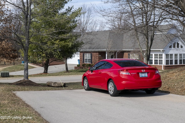 view of front of house featuring brick siding and a shingled roof