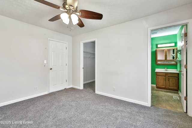 unfurnished bedroom featuring visible vents, a spacious closet, baseboards, and carpet flooring