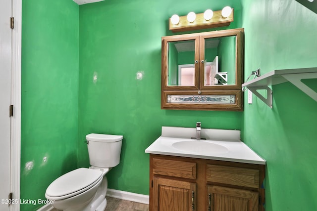 bathroom featuring vanity, toilet, and baseboards