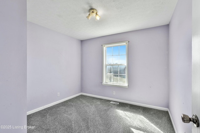 carpeted spare room with visible vents, a textured ceiling, and baseboards