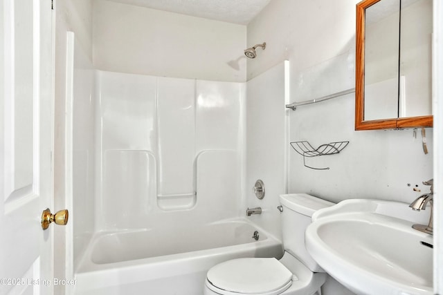 full bath featuring a sink, a textured ceiling, toilet, and bathing tub / shower combination