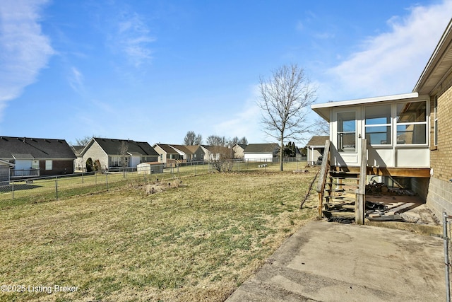 view of yard with entry steps, a residential view, and fence