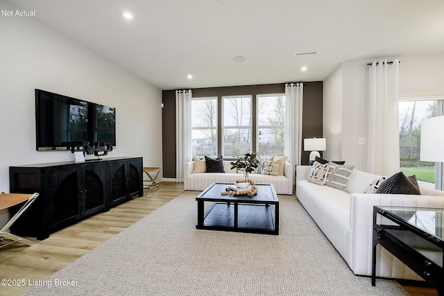 living room with light wood-style flooring, visible vents, a wealth of natural light, and recessed lighting