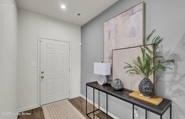 entrance foyer with baseboards, visible vents, and wood finished floors