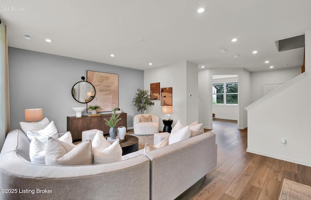 living room with baseboards, stairs, hardwood / wood-style flooring, and recessed lighting