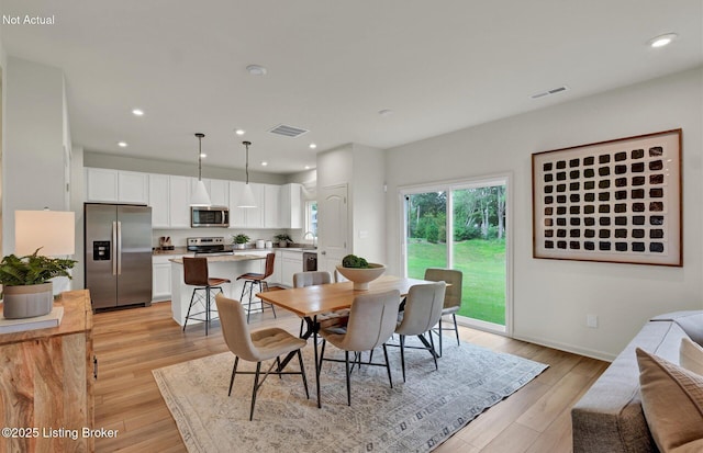 dining area with light wood finished floors, visible vents, and recessed lighting