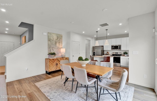 dining room featuring light wood finished floors, baseboards, visible vents, and recessed lighting