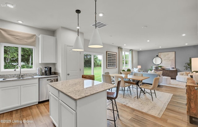 kitchen with visible vents, light wood-style floors, open floor plan, a sink, and dishwasher