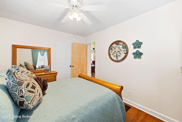 bedroom featuring a ceiling fan, baseboards, and wood finished floors