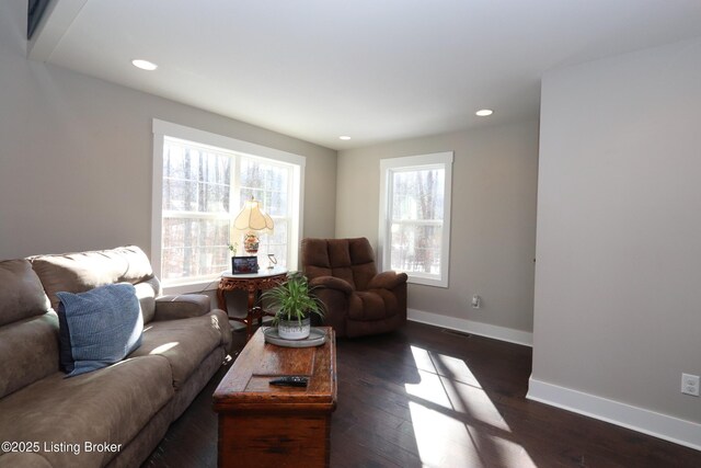 living room with dark wood-type flooring, recessed lighting, and baseboards