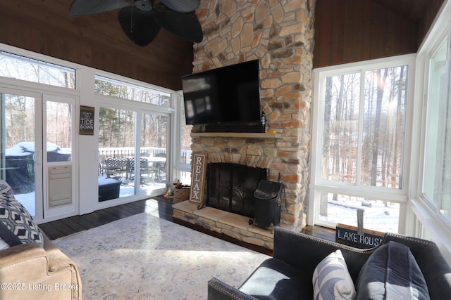 living room with ceiling fan, a fireplace, vaulted ceiling, and wood finished floors