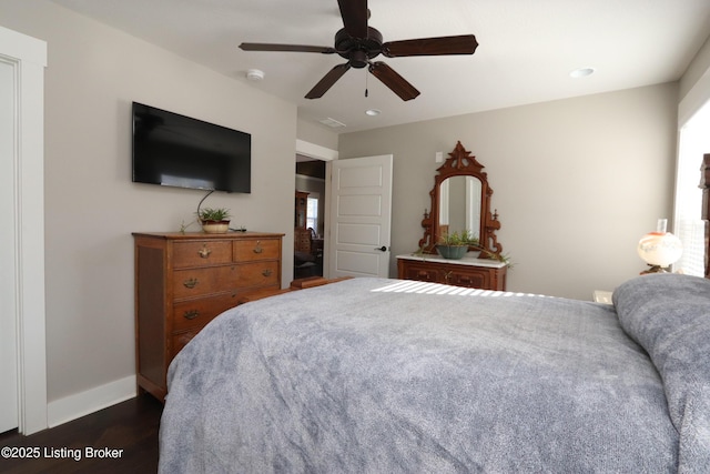 bedroom with ceiling fan, dark wood-style flooring, and baseboards