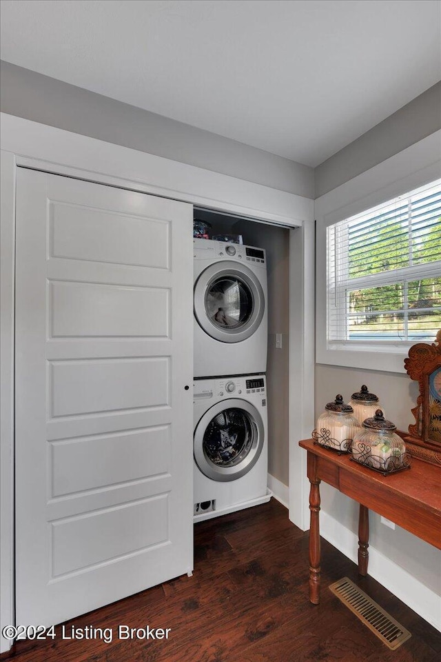 washroom featuring visible vents, laundry area, dark wood finished floors, and stacked washer and clothes dryer