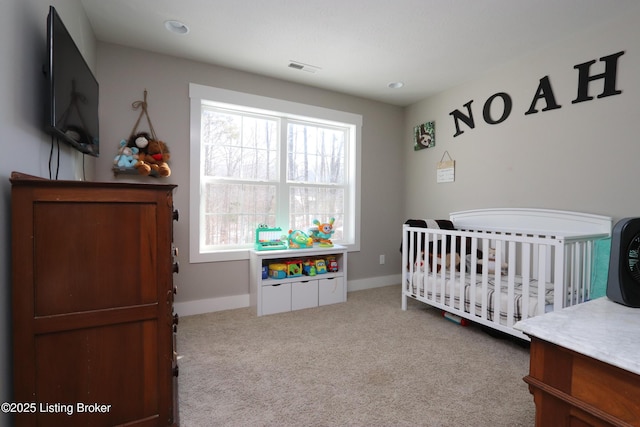 bedroom featuring a nursery area, light carpet, and baseboards