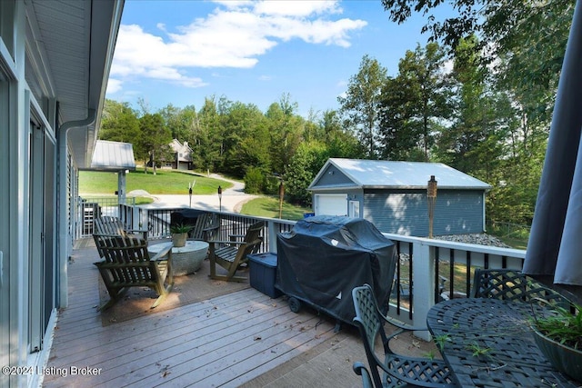 wooden deck with an outbuilding and area for grilling