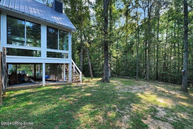 view of yard with a sunroom and stairs