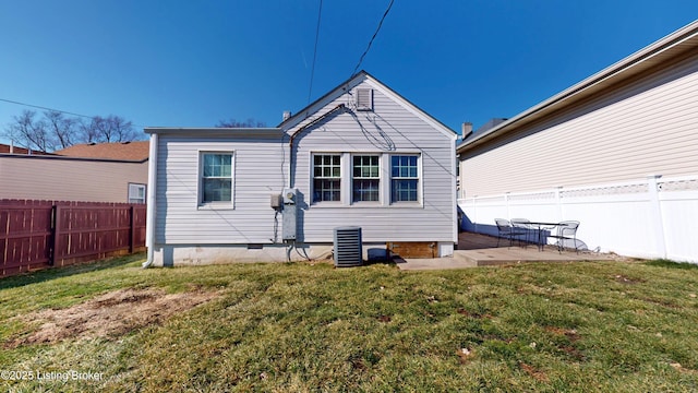 back of property with crawl space, a lawn, a patio area, and a fenced backyard