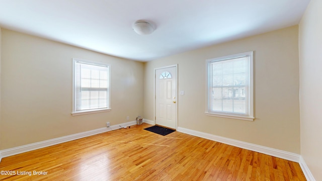 foyer with light wood-type flooring, plenty of natural light, and baseboards