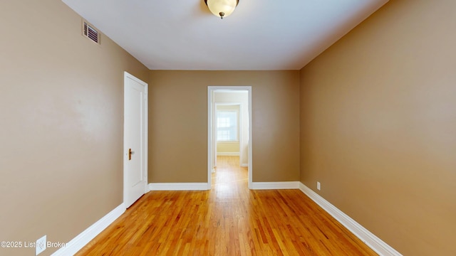 spare room featuring visible vents, light wood-style flooring, and baseboards