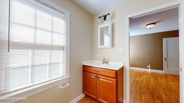 bathroom featuring baseboards, wood finished floors, and a healthy amount of sunlight