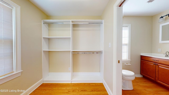 bathroom featuring vanity, wood finished floors, toilet, and baseboards