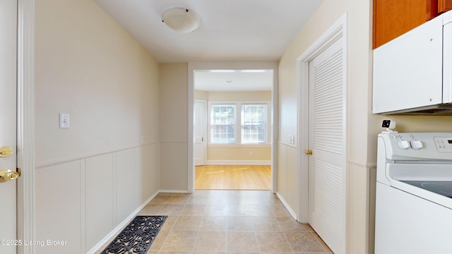 laundry area featuring cabinet space, light tile patterned floors, and washer / clothes dryer