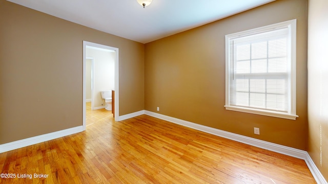 empty room featuring light wood-style floors and baseboards