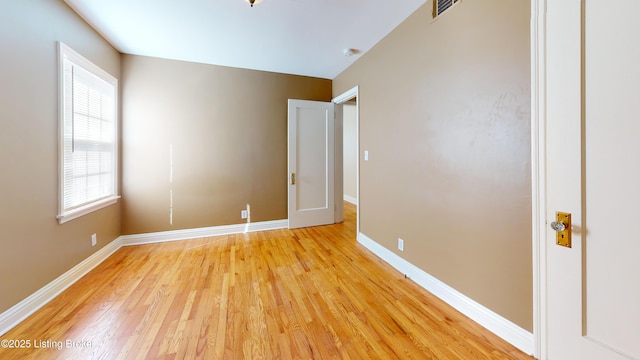 unfurnished bedroom with visible vents, light wood finished floors, and baseboards