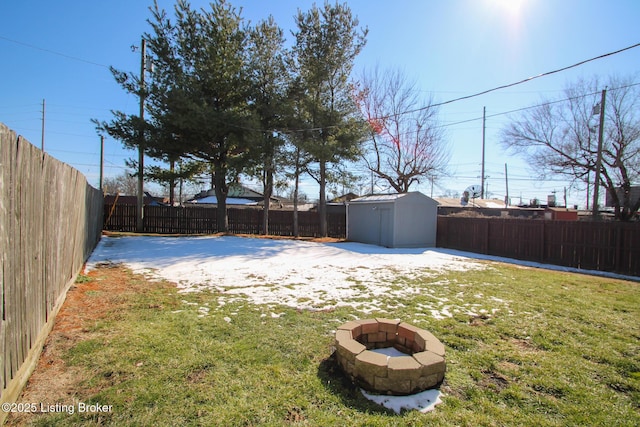 view of yard featuring a fenced backyard, an outdoor structure, a fire pit, and a storage shed