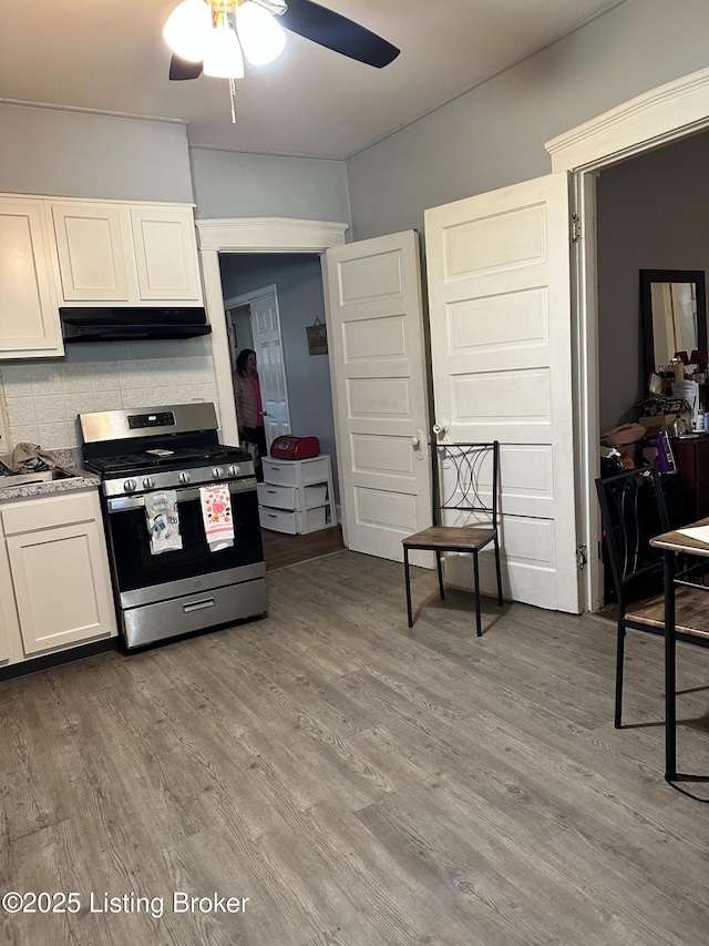 kitchen featuring tasteful backsplash, stainless steel range with gas cooktop, white cabinets, and light wood finished floors