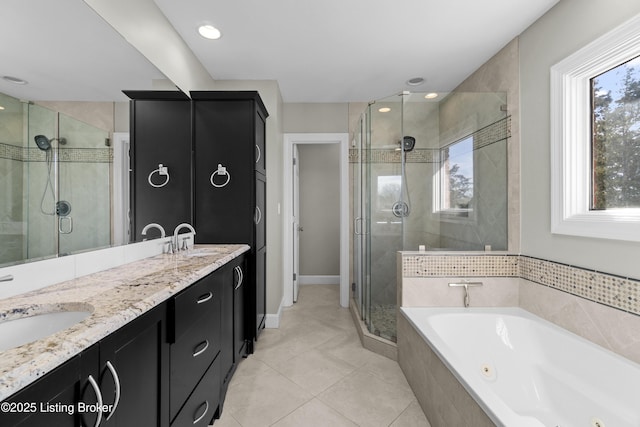 bathroom featuring a sink, a shower stall, a tub with jets, and double vanity