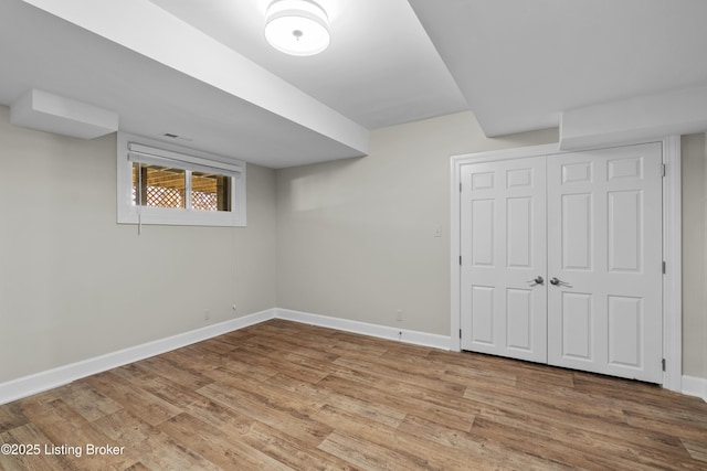 basement featuring baseboards and wood finished floors