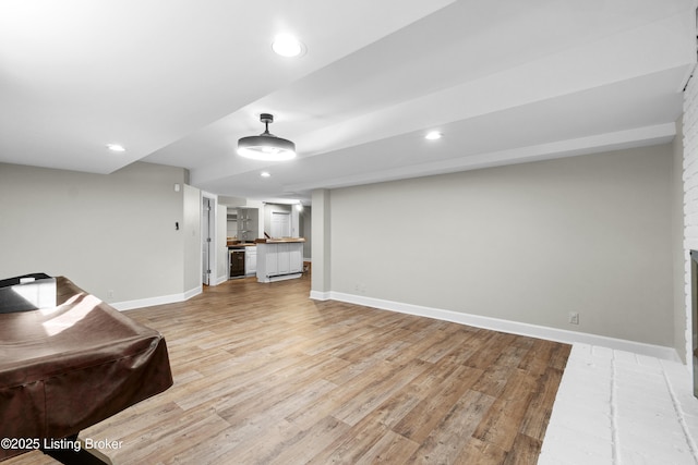 living area featuring light wood-type flooring, baseboards, and recessed lighting