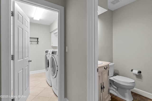 interior space with washing machine and dryer, toilet, vanity, visible vents, and tile patterned floors