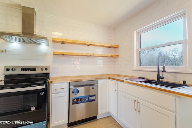 kitchen with open shelves, stainless steel appliances, wooden counters, a sink, and exhaust hood