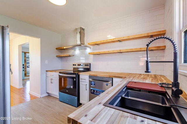 kitchen with open shelves, decorative backsplash, wood counters, wall chimney range hood, and range with electric cooktop