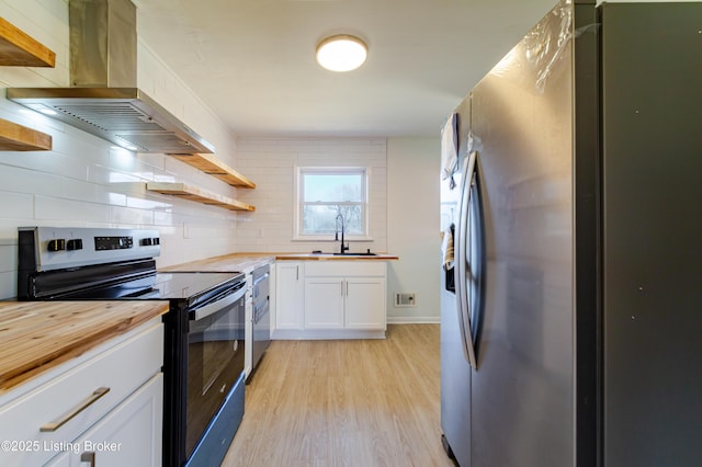 kitchen featuring wooden counters, appliances with stainless steel finishes, light wood-style floors, a sink, and extractor fan