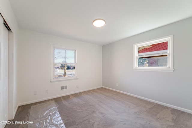 unfurnished bedroom with carpet, baseboards, visible vents, and a closet