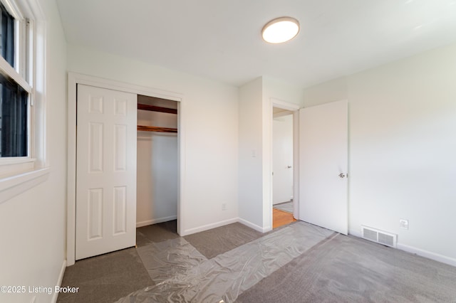 unfurnished bedroom with carpet floors, visible vents, and baseboards