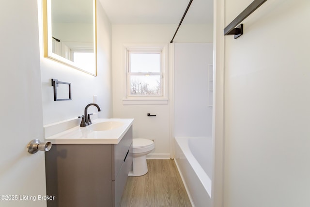 bathroom with baseboards, vanity, toilet, and wood finished floors