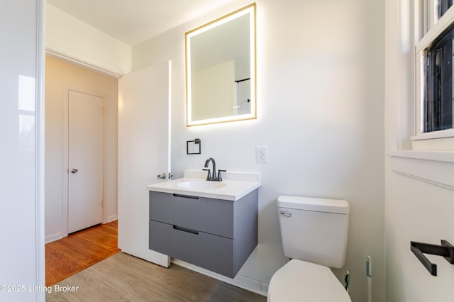 bathroom featuring toilet, wood finished floors, and vanity