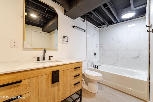 full bath with bathing tub / shower combination, vanity, toilet, and wood finished floors