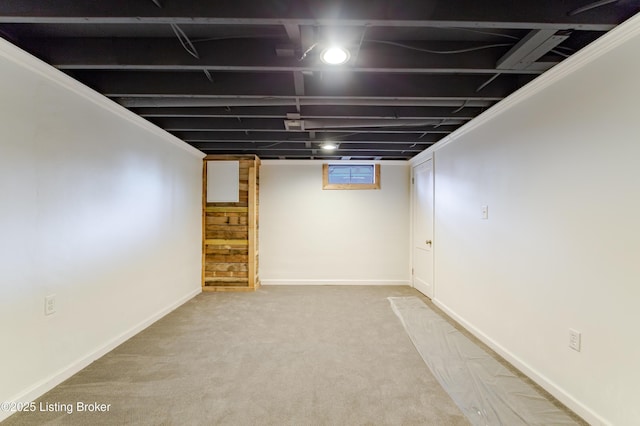 below grade area featuring carpet flooring and baseboards