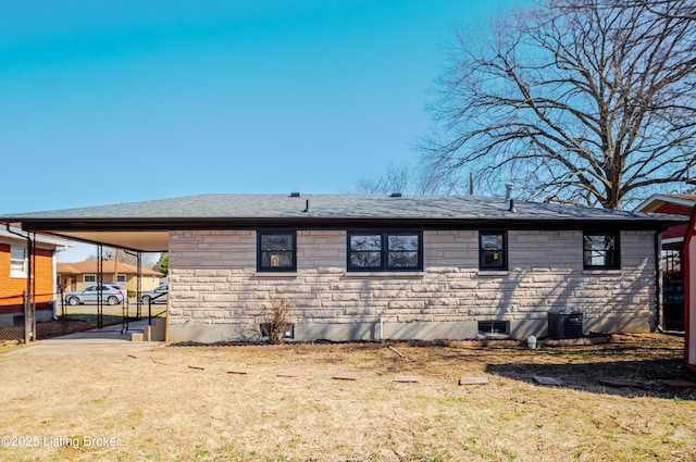 view of side of home with a shingled roof, a gate, fence, stone siding, and driveway