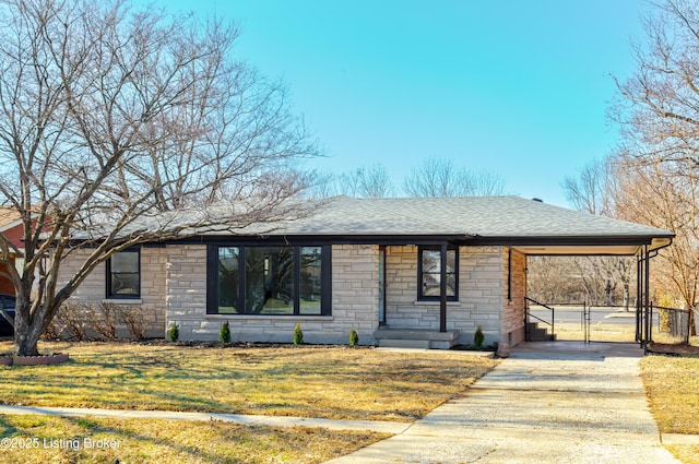 view of front of house with driveway, an attached carport, roof with shingles, a gate, and a front yard