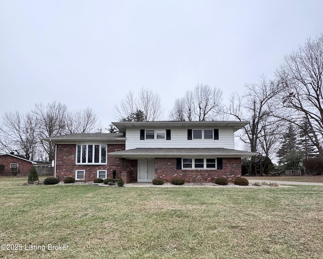 tri-level home with brick siding and a front yard