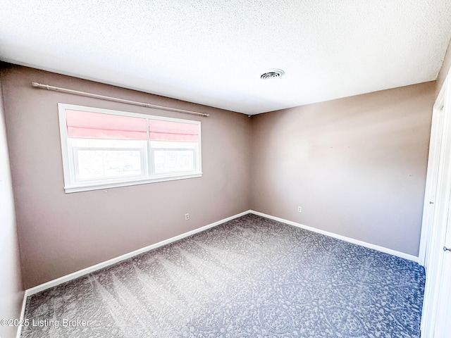 unfurnished room featuring a textured ceiling, carpet, visible vents, and baseboards