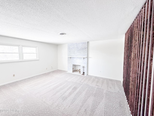 unfurnished living room with carpet, a fireplace, visible vents, and baseboards