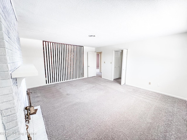 unfurnished room with visible vents, baseboards, a textured ceiling, and carpet flooring